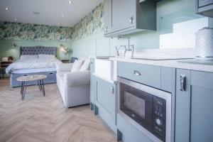 a kitchen with a couch and a bed in a room at The Langland bay look out in Swansea +43 photos