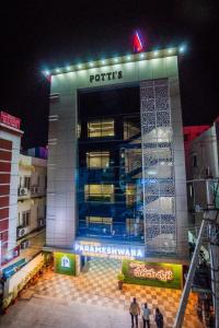 偉傑瓦拉的住宿－HOTEL PARAMESHWARA luxury awaits，一座建筑,人们在晚上站在外面