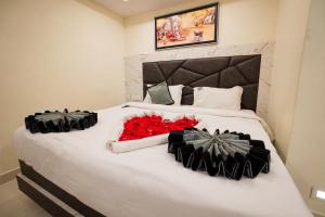 偉傑瓦拉的住宿－HOTEL PARAMESHWARA luxury awaits，一张大白色的床,上面有红色的鲜花