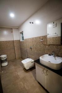 a bathroom with a sink and a toilet at HOTEL PARAMESHWARA luxury awaits in Vijayawāda