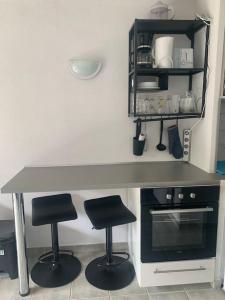 a kitchen with a counter and two stools under a table at Les Appartements de La Marina in Sanary-sur-Mer