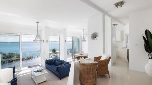 a living room with a blue couch and a view of the ocean at Riviera - Panoramic Water Views In The Heart Of Nelson Bay in Nelson Bay