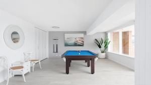 a white room with a pool table in it at Seaside Sanctuary - Waterfront Luxury Home with Heated Pool in Salamander Bay