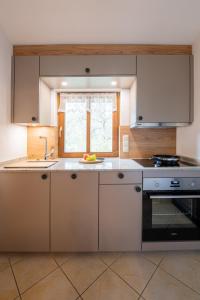 a kitchen with white cabinets and a sink at Ferienhäuschen Millinghof in Leogang
