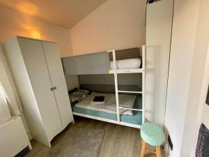a small room with a bunk bed and a chair at Eifelhäuschen am See in Biersdorf am See