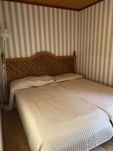 a bed in a room with a striped wall at Fritidshus i Sandbergen in Stora Frö