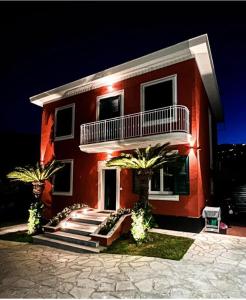 una casa rossa con palme di fronte di Elegante Villa Giardino + Posteggio privato a Santa Margherita Ligure