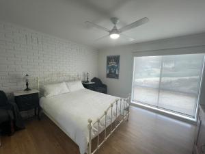 a bedroom with a white bed and a window at Dromana Panoramic Views in Dromana
