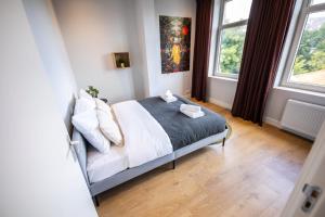 a bedroom with a bed and two windows at Spacious 2 Bedroom Serviced Apartment 77M2 -VP2B- in Rotterdam