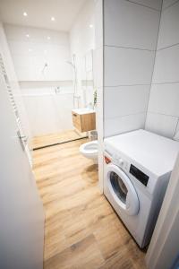 a washing machine in a bathroom with a toilet at Spacious 2 Bedroom Serviced Apartment 77M2 -VP2B- in Rotterdam