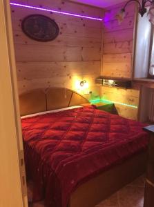 1 dormitorio con 1 cama con edredón rojo en Casa Maria, en Pieve Tesino