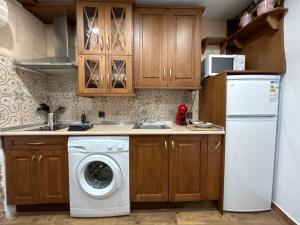 uma cozinha com uma máquina de lavar roupa e um frigorífico em Casa Pozo de la Nieve em Iznatoraf
