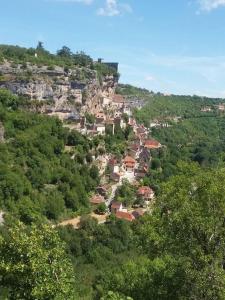 un village au sommet d'une colline plantée d'arbres dans l'établissement Gîte indépendant au calme avec vue panoramique, à Rocamadour