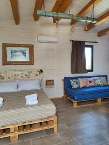 ein Schlafzimmer mit einem Bett und einem blauen Sofa in der Unterkunft AgriBarocco in Noto