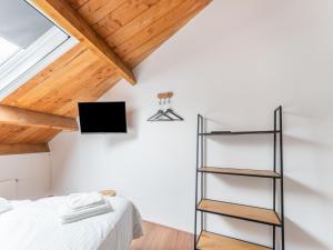 Habitación con cama y TV en la pared. en Pleasant holiday home in Goirle with sauna, en Goirle