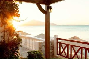 a view of the ocean from a house with a balcony at Potokaki Beachfront Hotel in Pythagoreio