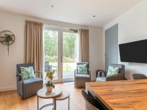 ein Wohnzimmer mit Stühlen und einem Flachbild-TV in der Unterkunft Pleasant holiday home in Goirle with sauna in Goirle