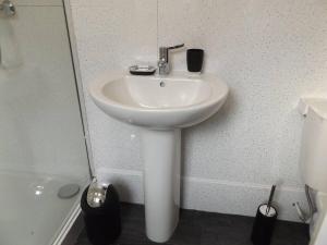 a white sink in the corner of a bathroom at Forest Park House in Hanley