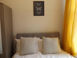 uma cama com duas almofadas e uma fotografia na parede em Forest Park House em Hanley