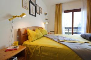 a bedroom with a bed with yellow sheets and a lamp at Ski-to-door apartment Waldrand in Bad Kleinkirchheim