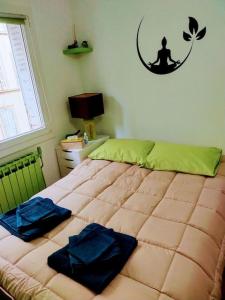 a bedroom with a bed with two blue pillows on it at Le Passe-Port pour Marseille in Marseille