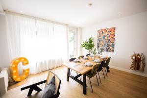 een eetkamer met een houten tafel en stoelen bij Premium 2 Bedroom Serviced Apartment 71M2 -VP2C- in Rotterdam