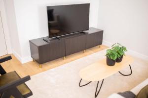 a living room with a flat screen tv and a table at Premium 2 Bedroom Serviced Apartment 71M2 -VP2C- in Rotterdam