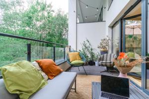 a living room with a couch and a laptop on a balcony at Lumina comfy apart in Park na Zdrowiu in Łódź