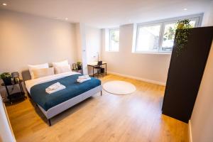 a bedroom with a bed with blue sheets and a window at Distinct 2 bedroom Serviced Apartment 84m2 -VP2D- in Rotterdam