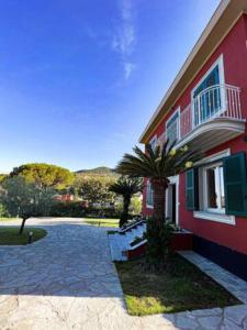 una casa rossa con una palma di fronte di Elegante Villa Giardino + Posteggio privato a Santa Margherita Ligure