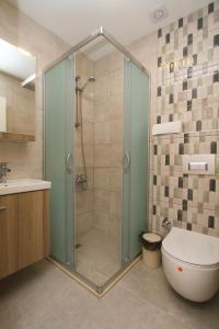a bathroom with a shower with a toilet and a sink at Marinda Otel in Cesme