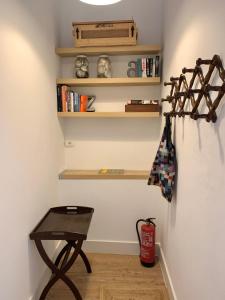 una habitación con una mesa y un estante con libros en La Casa de Vegueta en Las Palmas de Gran Canaria