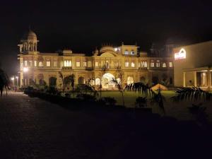 a large building with lights in front of it at night at The Grand Barso (A Luxury Heritage) in Bharatpur