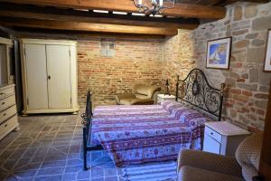 ein Schlafzimmer mit einem Bett in einer Ziegelwand in der Unterkunft Il Poggio in Mombaroccio