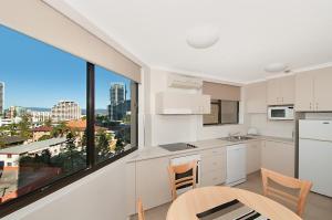 una cucina con mobili bianchi e una grande finestra di Voyager Resort a Gold Coast