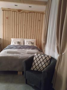 a bedroom with a large bed and a chair at Domek na Górce in Zakopane