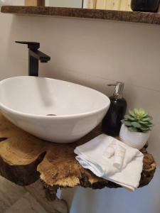 Domek na Górce في زاكوباني: حمام مع حوض أبيض على طاولة خشبية