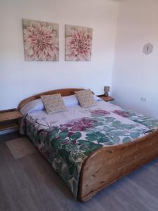 ein Schlafzimmer mit einem Holzbett in einem Zimmer in der Unterkunft Villa Sila in El Paso