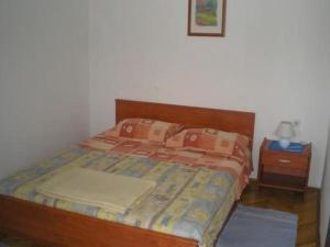 łóżko z 2 poduszkami i stolikiem nocnym z łóżkiem sidx sidx sidx w obiekcie Apartment in Biograd na Moru with Terrace, Air conditioning, Wi-Fi 4801-1 w Biogradzie na Moru
