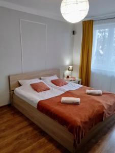 a bedroom with a large bed with two towels on it at Apartament Warmińska in Barczewo