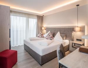 ein Hotelzimmer mit einem Bett und einem Schreibtisch in der Unterkunft Aktiv Hotel Schweizerhof Kitzbühel in Kitzbühel
