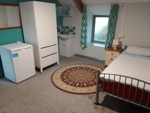 a small bedroom with a bed and a sink and a sink at Dolphins Backpackers in Tintagel