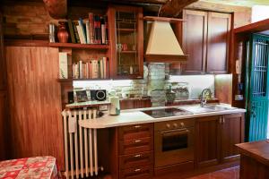 cocina con armarios de madera, fregadero y radiador en Il Poggio, en Mombaroccio