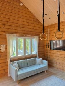 Una sala de estar con un sofá y dos ventanas. en Villa Orohat 1, en Rovaniemi