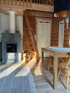 Una sala de estar con una mesa y una chimenea. en Villa Orohat 1, en Rovaniemi