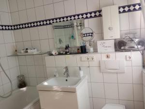 a bathroom with a sink and a toilet and a tub at Ferienwohnung Miraflor in Solingen +18 photos