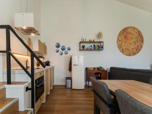 een keuken en een woonkamer met een tafel en een koelkast bij Charming holiday home in Kaatsheuvel with hot tub in Kaatsheuvel