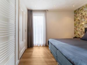 een slaapkamer met een bed en een raam bij Charming holiday home in Kaatsheuvel with hot tub in Kaatsheuvel
