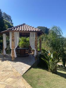 um gazebo de madeira com uma mesa num quintal em Sítio dos Coqueiros, em meio a natureza com piscina em Carlos Barbosa