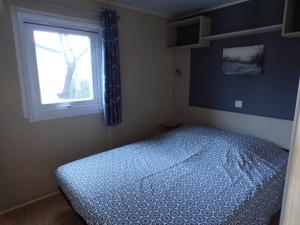 sypialnia z łóżkiem i oknem w obiekcie Mobil Home Les salins de la gardiole w mieście Vic-la-Gardiole